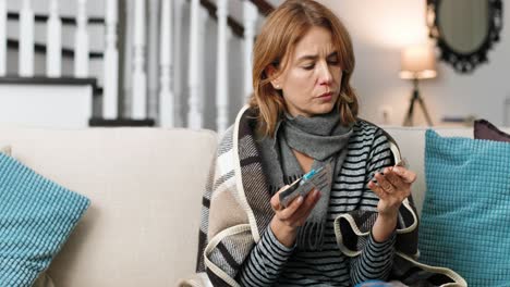 sick woman in on the sofa and choosing pills