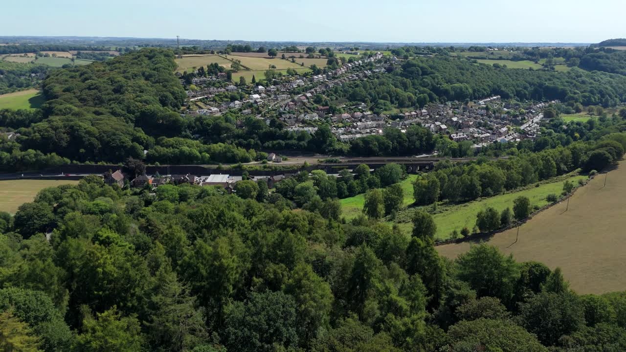 Vista aérea con dron de valles pintorescos y ondulantes colinas con exuberantes árboles verdes en Ambergate Derbyshire Dales, Inglaterra, Reino Unido, en un día soleado y brillante