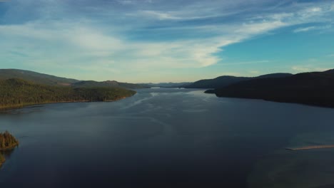 Lago-Tranquilo-Rodeado-De-Montañas-Boscosas-Durante-La-Puesta-De-Sol