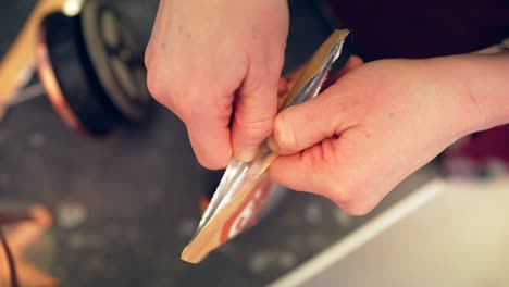 Caucasian-hands-open-sealed-foil-coffee-bag-in-slow-motion