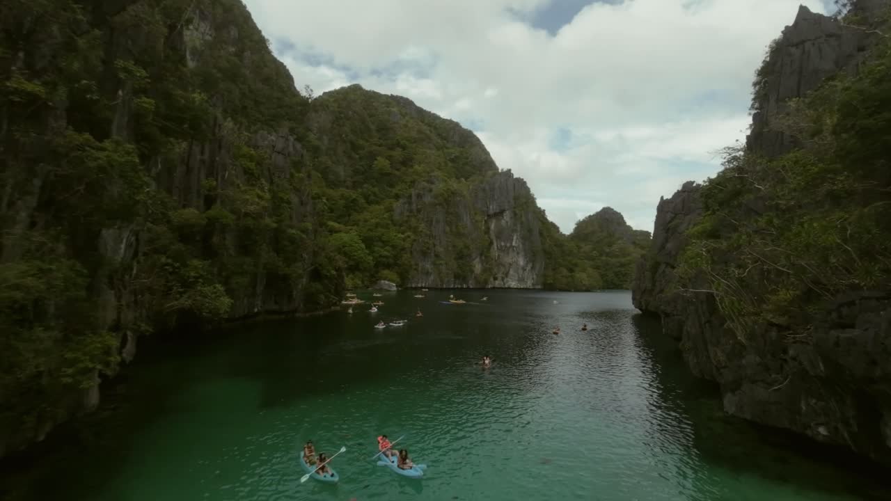 Cảnh quay drone về nhóm khách du lịch khám phá phong cảnh El Nido bằng thuyền kayak, Philippines.