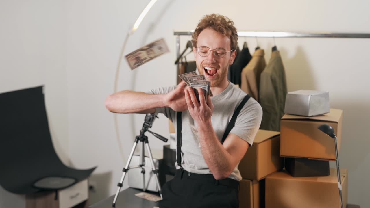 радостный кудрявый мужчина разбрасывает деньги на мини-складе