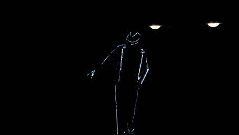 un tipo con un traje de led baila en la oscuridad