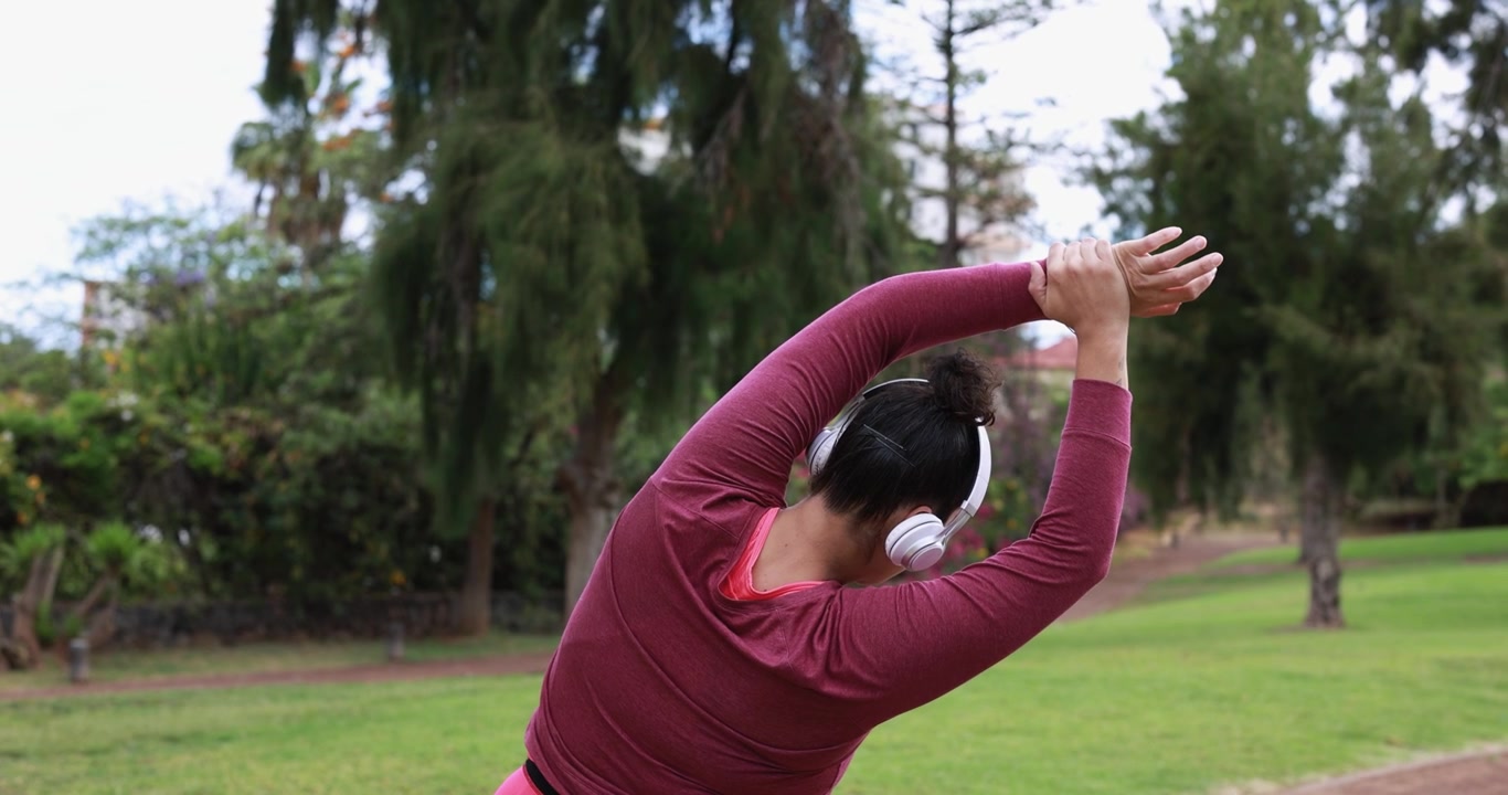 Woman Stretching Arms and Shoulders in Park