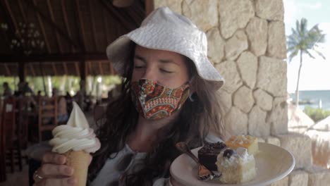 caucasian female wearing a face mask and with a dessert plate and ice cream