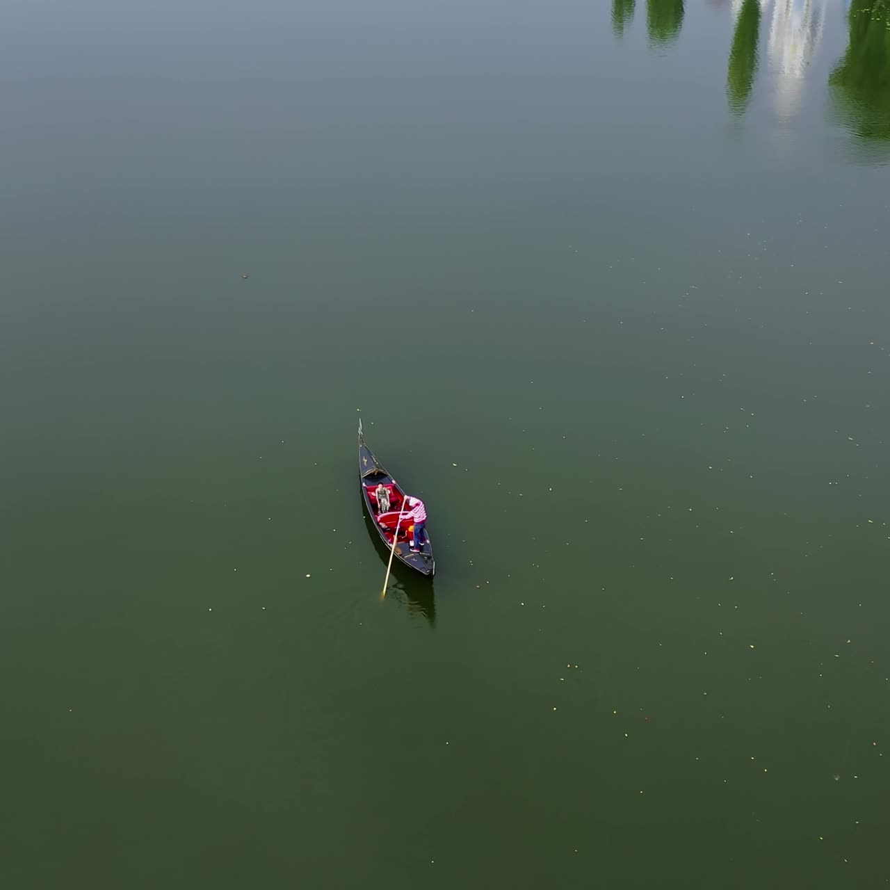 Boat floating on water. View from above on gondola sailing along the wide river. Romantic atmosphere. Aerial view.