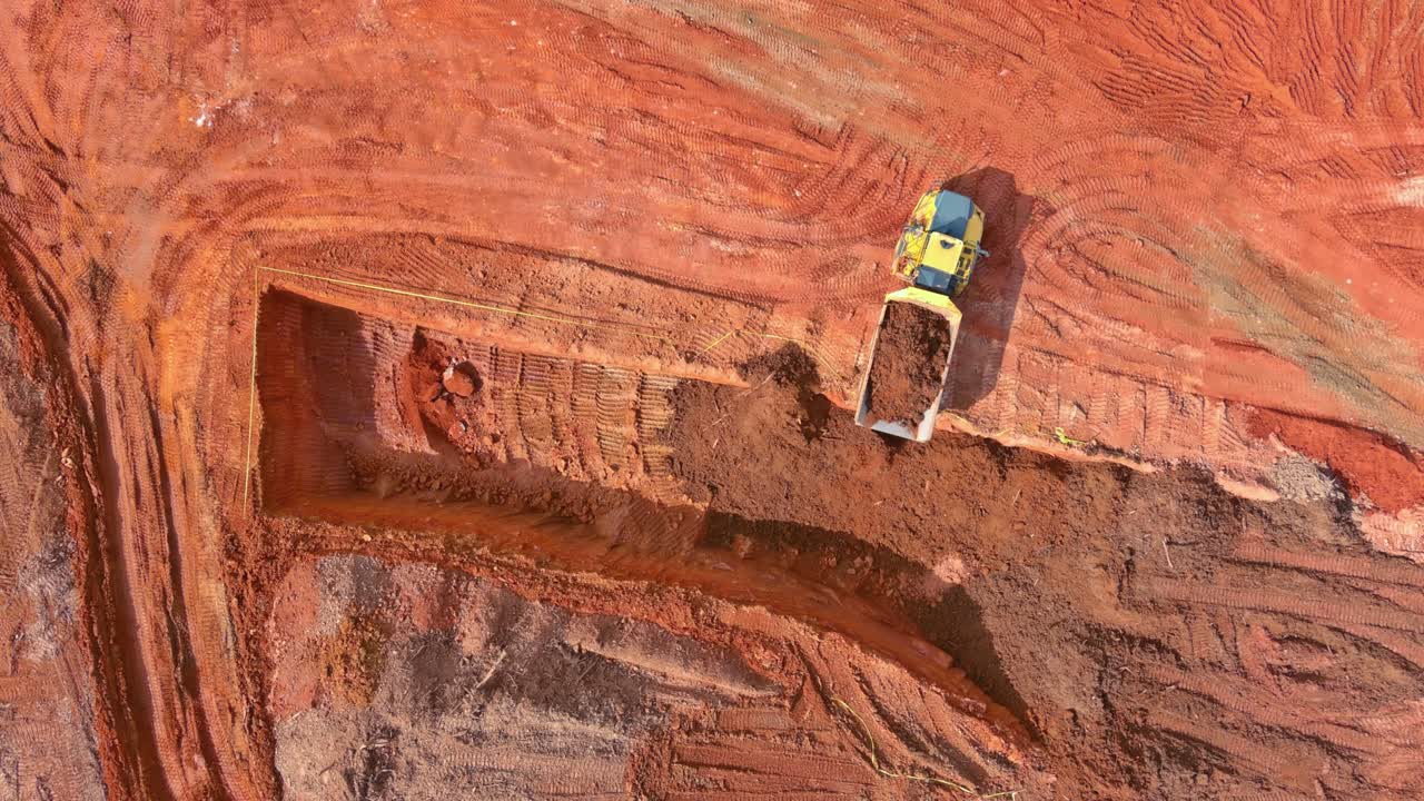 Aerial top view of earth moving heavy equipment at construction site