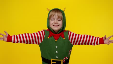 Kid-teen-girl-in-Christmas-elf-Santa-helper-costume-blows-air-kisses-at-camera,-hugging,-embracing