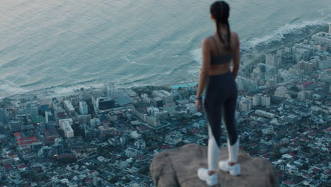 Mujer-Independiente-Con-Los-Brazos-Levantados-En-La-Cima-De-La-Montaña-Celebrando-El-Logro-Chica-Al-Borde-Del-Acantilado-Mirando-La-Hermosa-Vista-Al-Atardecer-Disfrutando-De-La-Aventura-Del-Viaje