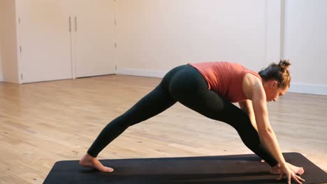 Woman-doing-stretching-exercise-on-exercise-mat