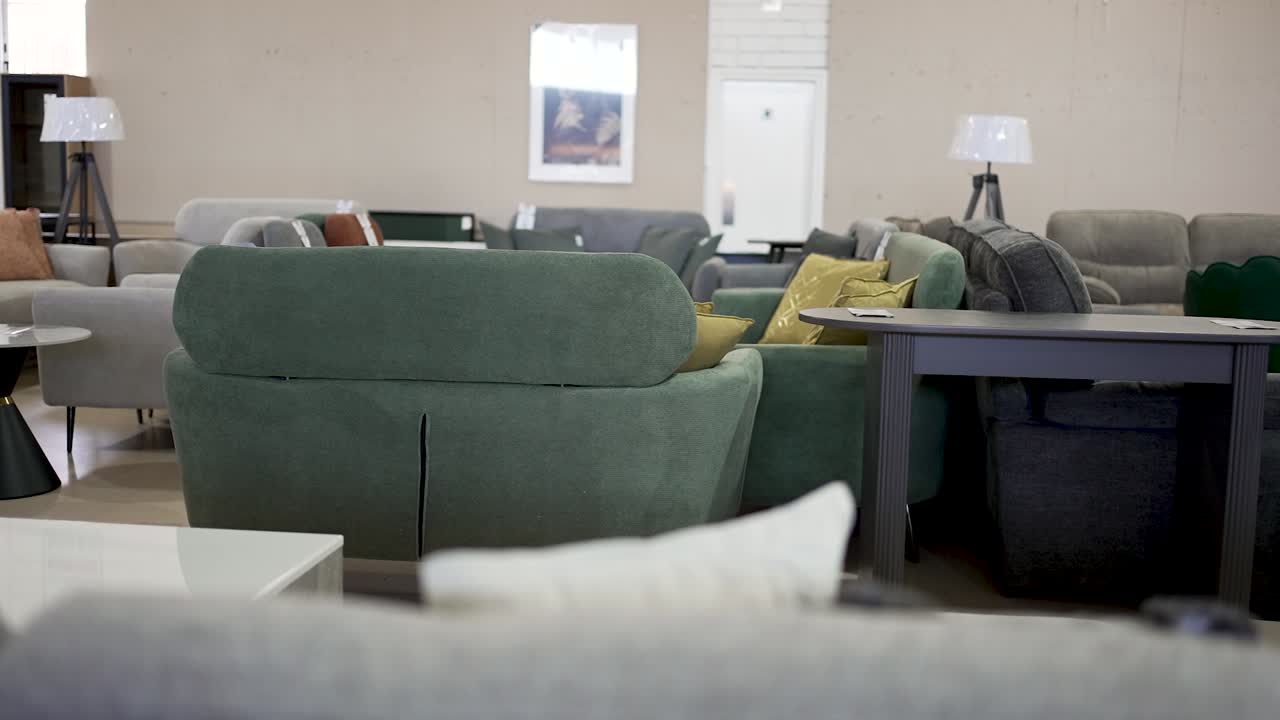 Explore a spacious furniture store filled with stylish sofas and chairs. Browse through various colors and textures perfect for your living room. Find comfort and elegance today