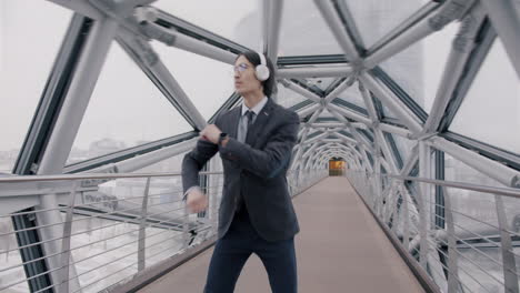businessman dancing on a modern city bridge