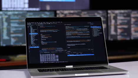 laptop displaying code on multiple monitors
