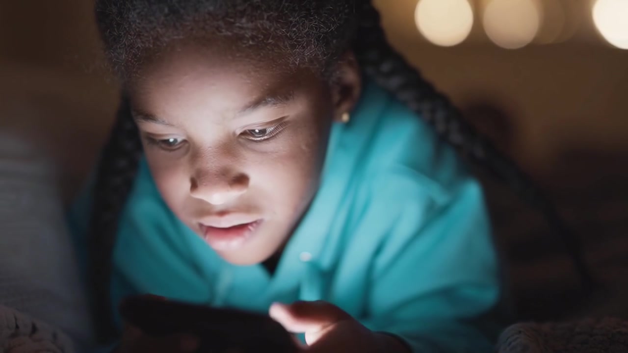 Young Black Girl Using Smartphone in Dark Room at Night