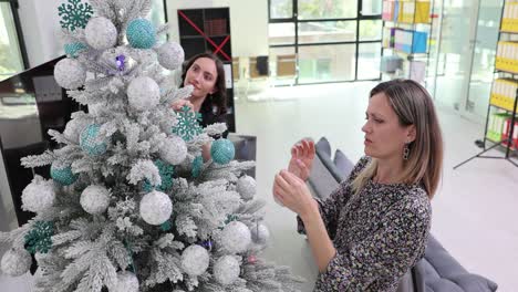 Women Decorating Christmas Tree in Office