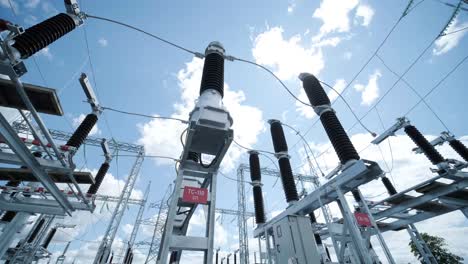 muchos aislantes eléctricos de alto voltaje en la subestación de energía contra un fondo de cielo azul