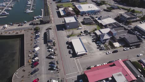 Dramatic-4k-aerial-dolly-over-harbor-and-coastal-town-of-Bandon,-Oregon-with-midday-lighting