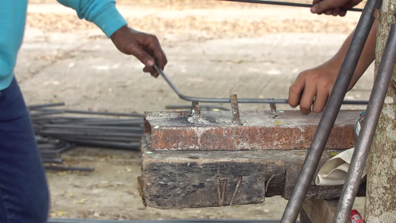 노동자가 철 라인을 사각형 모양으로 구부려 건설 건물로.