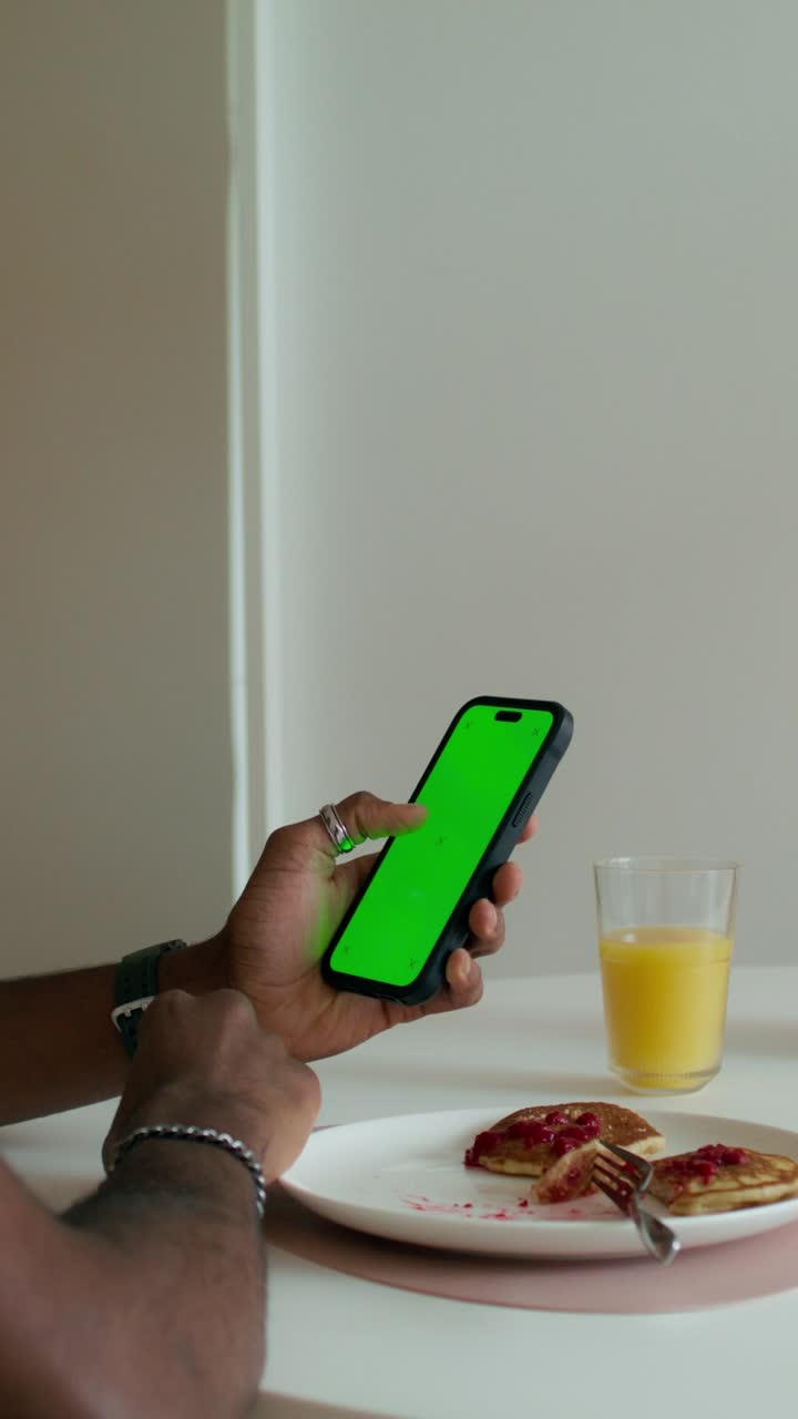 hombre usando teléfono inteligente durante el desayuno