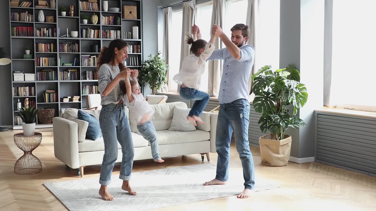 행복 한 부모 는 현대적 인 거실 에서 자녀 들 과 함께 춤추고 있다