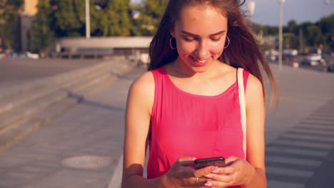 chica caminando por la calle usando un teléfono inteligente
