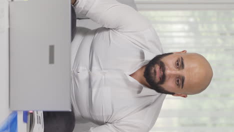 Vertical-video-of-Home-office-worker-man-nervously-waiting-at-laptop.