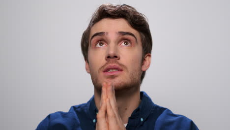 hombre guapo orando en el estudio. retrato de hombre enfocado diciendo una oración