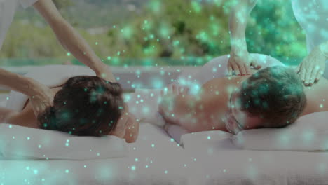 animación de puntos de luz sobre una pareja caucásica recibiendo masaje