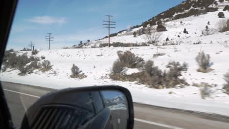 view of snow covered countryside while on a freeway