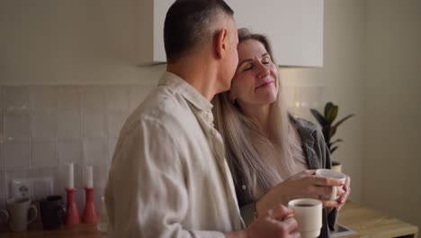 una pareja disfrutando de café en la cocina.
