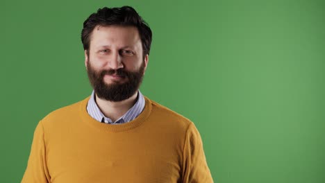 hombre con el número 99 señal. alegre hombre de barba blanca de buen aspecto en suéter amarillo muestra el número noventa y nueve en la hoja blanca. llave cromada, pantalla verde, espacio de copia
