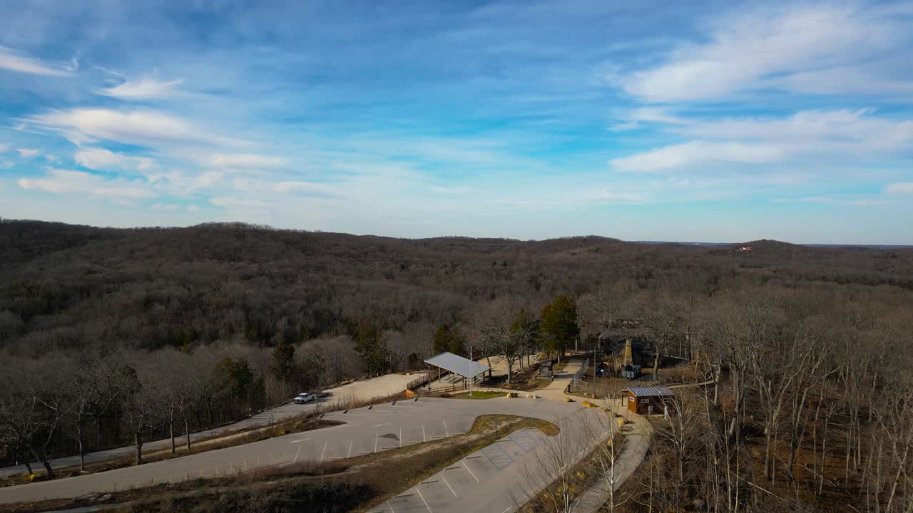 A drone shot showing the top of the trail at Don Robinson State Park in Missouri. There is a clear blue winter sky above rolling hills of trees