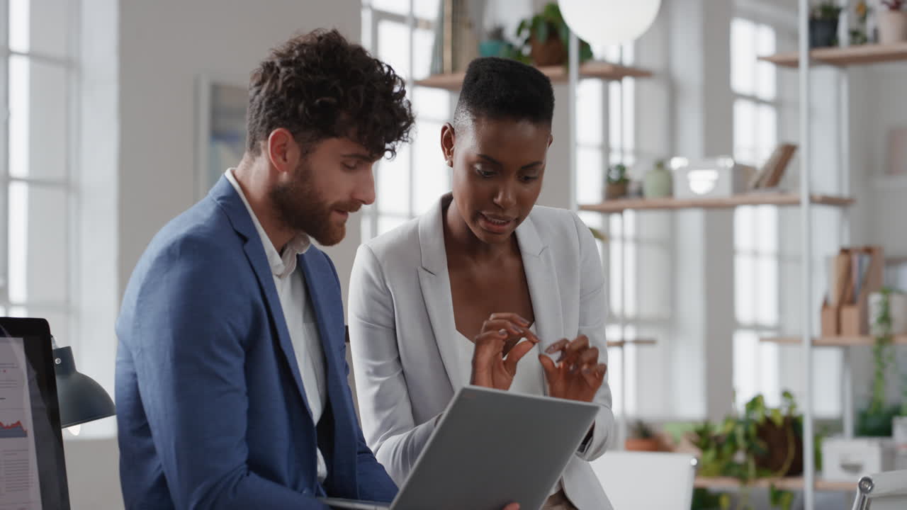 african american business woman team leader brainstorming with colleague using laptop computer showing ideas pointing at screen working together in office