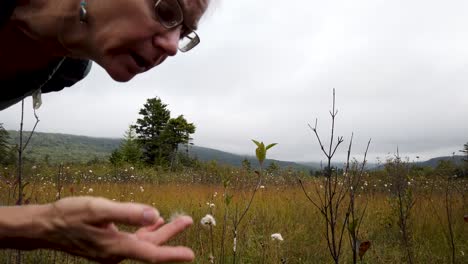 Closeup-of-pretty,-blonde,-mature-woman-looking-at-cotton-grass-at-Cranberry-Glades-Botanical-Area-boardwalk