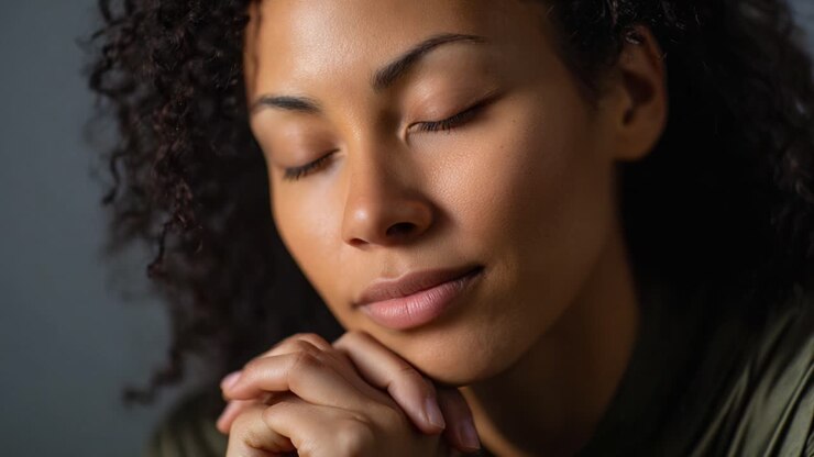 Contemplative Moment: A Woman in Reflection with Closed Eyes and Hands Together, Capturing a Sense of Peace and Inner Harmony in Soft Lighting
