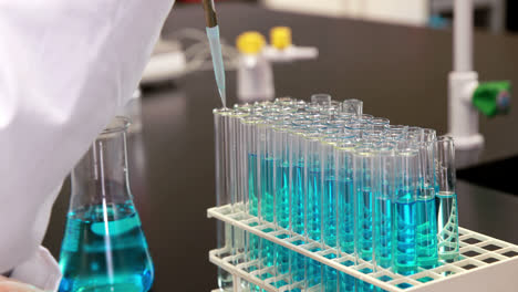 young scientist using pipette to put chemical in test tube