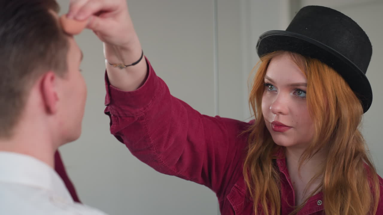 beautiful woman applying makeup on client smiling together while mirror reflects joyful beauty session in salon setting capturing professional cosmetic artistry and facial transformation process