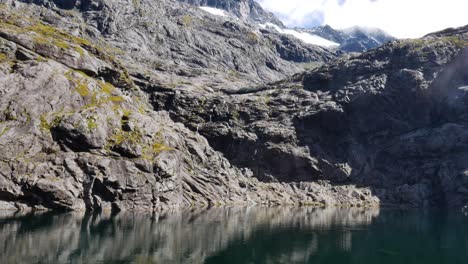 inclinación hacia abajo del lago natural rodeado de montañas rocosas en verano - gertrude saddle, nueva zelanda