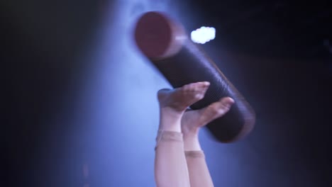 close up of live circus act where someone has a tube in his feet and spins it acrobat lifestyle circus time