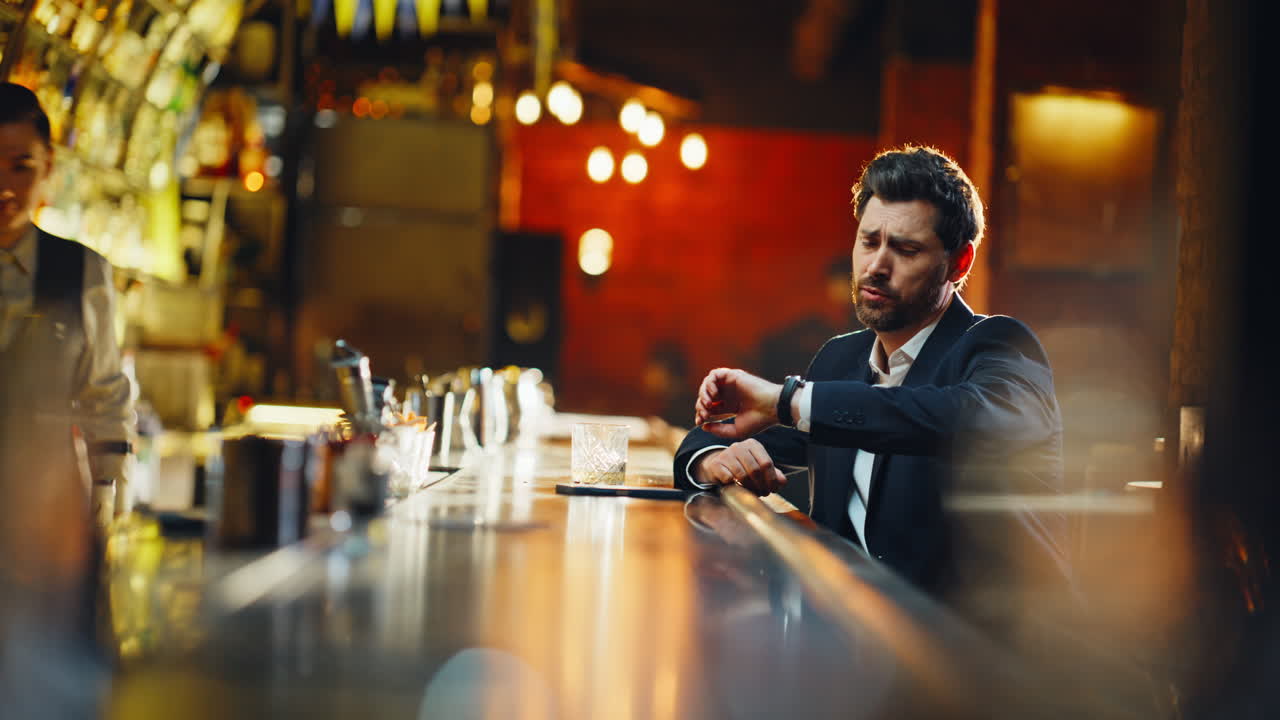 Lonely businessman resting bar counter at late hours. Smiling man finalize bill