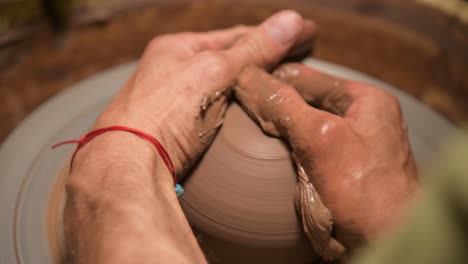 male hands making a clay bowl on a potter's wheel. handicraft and production of exclusive tea ware made of clay