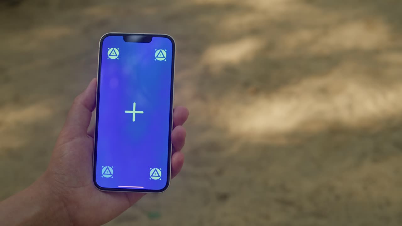 Young woman holding phone chroma key screen in the lovely park close-up. Girl with green screen on smart phone. Nature.