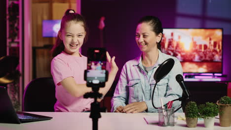 little girl and her mother recording reaction to internet clips for family channel