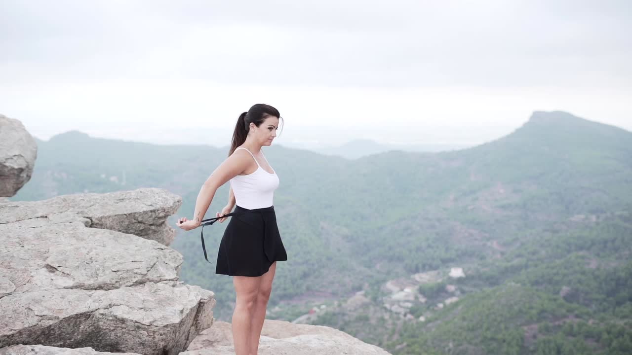 Woman in white swimsuit on a mountaintop