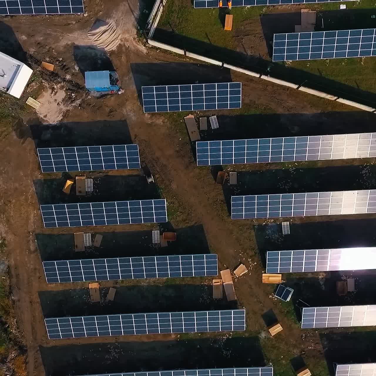 Solar panels in field. Renewable energy, technology, electricity, service, green power. View from above. Video from drone