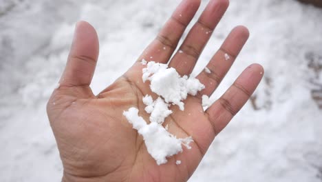 hand holding a clump of snow