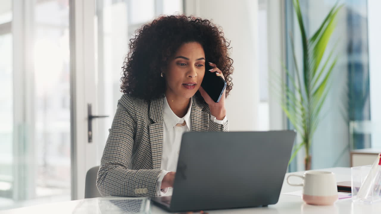 Businesswoman on a phone call working on laptop in office