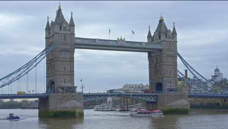 boats passing under tower bridge on cloudy day, london