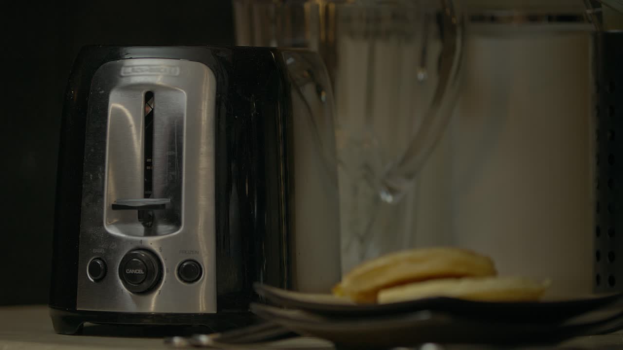 Frozen waffles pop up from toaster in a kitchen in the morning