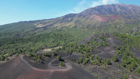 tourist people hike on mount etna volcano craters in sicily, italy - aerial 4k circling